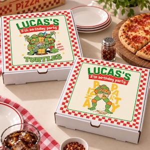 May include: Two square white cardboard pizza boxes with red and white checkered borders. The boxes feature green and red text reading LUCAS'S 5th birthday party TURTLES and PIZZA PARTY, with colourful illustrations of Teenage Mutant Ninja Turtles.