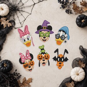 Peut inclure: Six écussons brodés représentant des personnages Disney en costumes d'Halloween : Daisy Duck avec un masque, Mickey Mouse avec un chapeau violet et un masque vert, Donald Duck avec des lunettes spirales, Minnie Mouse avec un nœud à pois et des lunettes citrouille, Goofy avec des lunettes citrouille et Pluto en chauve-souris.