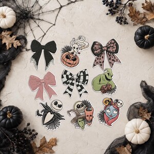 May include: A collection of nine decorative stickers featuring various designs including black and pink bows, a ghost dog on a pumpkin, a green monster with dice, a skeleton character, a trio of masked figures, and a stitched female character.
