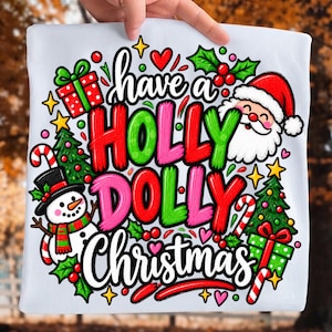 May include: A white t-shirt featuring a colorful graphic with the text have a HOLLY DOLLY Christmas. The design includes a smiling Santa Claus, a snowman with a top hat, two decorated Christmas trees, gift boxes, candy canes, and small hearts.