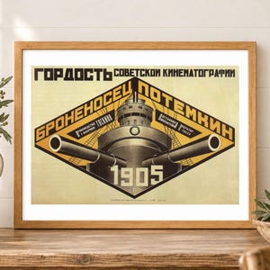 May include: A framed poster featuring a graphic illustration of a battleship with two large cannons extending outward. The design includes yellow and black geometric shapes, the text "БРОНЕНОСЕЦ ПОТЕМКИН", "1905", and other Russian text.