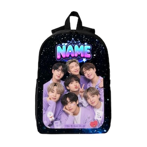 Puede incluir: Una mochila negra con un fondo de cielo estrellado y la palabra NAME en letras con degradado azul y rosa. El frente muestra una fotografía grupal de siete personas con suéteres de color violeta claro, decorada con pequeñas pegatinas de dibujos.