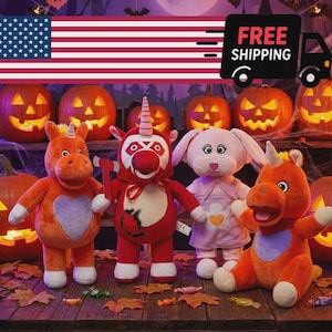 May include: Four plush toys arranged in a row: an orange unicorn with a purple heart, a red creature with a horn and an axe, a light pink rabbit in a dress, and an orange unicorn. They are set against a backdrop of lit jack-o'-lanterns.