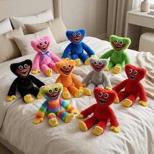May include: A collection of nine plush toys in various colors including blue, pink, green, black, orange, gray, red, and rainbow. Each plush features a wide, toothy grin, large eyes, and yellow hands and feet, arranged on a white bedspread.