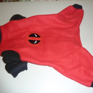 Pode incluir: Pijama para cachorro vermelho e preto com um logotipo preto e vermelho do Deadpool nas costas.