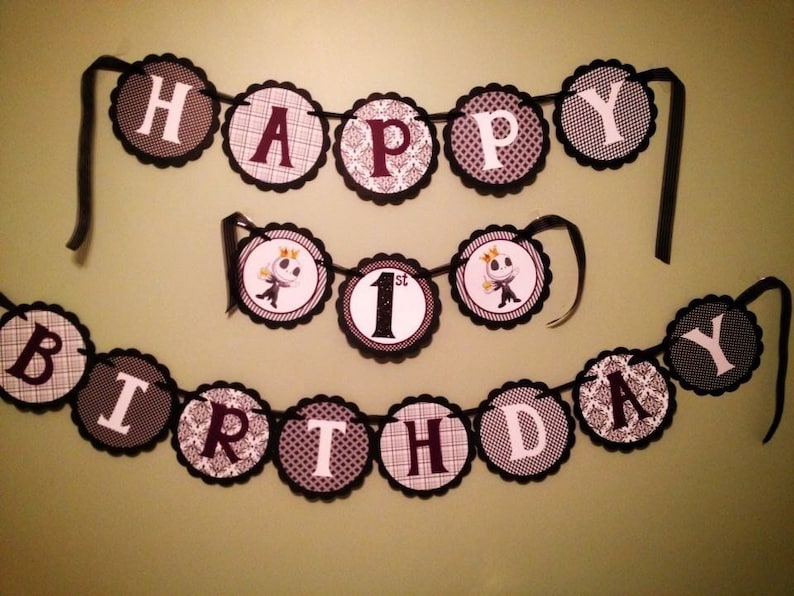 May include: Black and white birthday banner with the words "Happy 1st Birthday" and images of a character from the movie "The Nightmare Before Christmas".