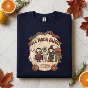 Può includere: Una felpa girocollo blu navy con una grafica di luna piena, pipistrelli e zucche. Il testo recita FULL MOON FAMILY e EST. 1991. L'illustrazione raffigura un fantasma, un vampiro, una mummia, una strega e un personaggio con la testa di zucca.