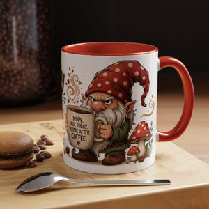 May include: A white ceramic mug with a red interior and handle, featuring a graphic of a grumpy gnome wearing a red polka-dot hat, holding a smaller mug with the text "NOPE. NOT TODAY. MAYBE AFTER COFFEE." and a small red heart below the text.