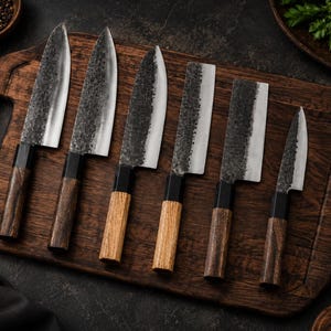 May include: A set of six kitchen knives with hammered metal blades and wooden handles. The blades feature a dark, textured finish near the spine and a polished edge. The handles are cylindrical, crafted from wood with black bolsters.