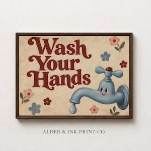 May include: A framed wall art print featuring the text Wash Your Hands in dark red cursive lettering. A light blue cartoon faucet with a smiling face is dripping a single drop of water, surrounded by small pink and blue flowers on a cream background.