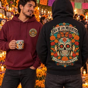 May include: A maroon hoodie with a small skull graphic on the chest and a black hoodie featuring a large, colorful Dia de los Muertos skull, butterfly, and marigold floral design on the back with the text Celebrating Life Honoring the Dead.