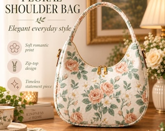 May include: A crescent-shaped shoulder bag featuring a cream-colored fabric with a floral pattern of pink roses and green leaves. The bag has a single top handle, gold-toned hardware, and a dual zipper closure at the top opening.