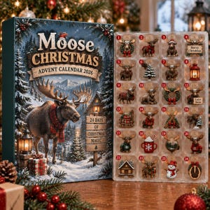 Pode incluir: Um calendário do Advento Moose Christmas 2026 com uma caixa que mostra um alce com um cachecol vermelho numa floresta nevada, e um tabuleiro de plástico transparente com 24 compartimentos numerados contendo pequenas figuras de Natal.