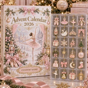 Op de afbeelding: Een 2026 adventskalenderdoos met een ballerina-illustratie en een doorzichtig plastic dienblad met vierentwintig miniatuur goudkleurige metalen ornamenten, waaronder balletschoenen, een notenkraker, een zwaan en een kroon.