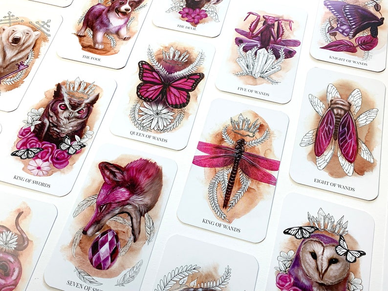Pink and purple tarot cards featuring animals, plants, flowers and crystals