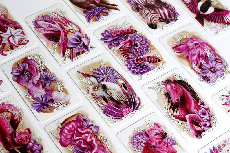 Pink and purple tarot and oracle cards featuring animals, flowers, plants and crystals.