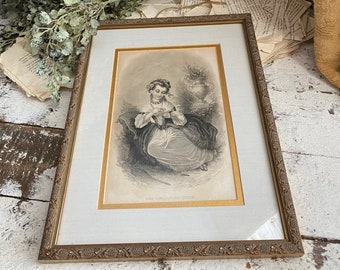 May include: A framed black and white print of a young woman sitting in a garden setting. She is wearing a dress and holding a piece of yarn. The print is titled "The Amiable Knitter".