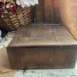Pu&ograve; includere: Una scatola di legno con un coperchio incernierato e una chiusura in metallo. La scatola &egrave; in legno marrone scuro e ha un aspetto rustico.