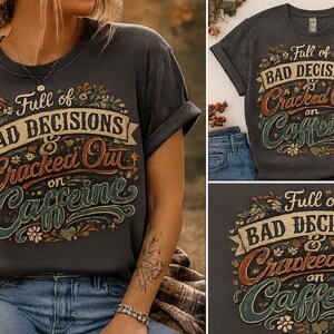 May include: A charcoal gray short-sleeve t-shirt featuring a graphic design with the text Full of BAD DECISIONS & Cracked Out on Caffeine. The lettering is styled in various fonts and colors, surrounded by floral and leaf illustrations.