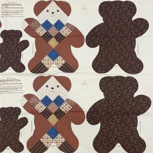 May include: A printed fabric panel featuring cut-out patterns for teddy bears. The design includes front pieces with a patchwork quilt aesthetic in brown, blue, and tan, and solid dark brown back pieces with a small white floral print pattern.