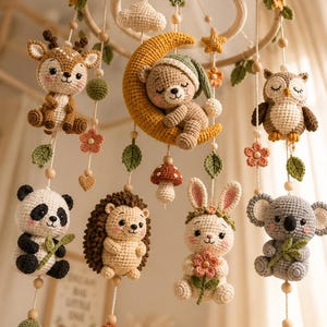 Può includere: Una giostrina all'uncinetto con un anello in legno decorato con foglie verdi e piccoli fiori. Dall'anello pendono figure all'uncinetto che includono un cervo, un orso su una luna gialla, un gufo, un panda, un riccio, un coniglio e un koala.
