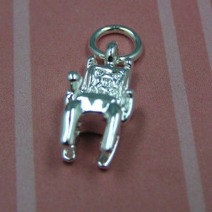 Puede incluir: Encanto de plata en forma de mecedora. La silla tiene un diseño detallado y un bucle en la parte superior para sujetarlo a una pulsera o collar.