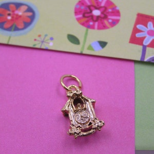 Puede incluir: Encanto dorado en forma de reloj de cuco. La esfera del reloj tiene agujas negras y números romanos. El encanto tiene un bucle en la parte superior para sujetarlo a un collar o pulsera.