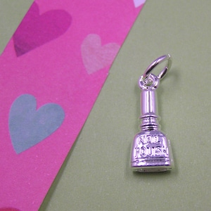 May include: Silver charm in the shape of a nail polish bottle with the words "Nail Polish" on the front.