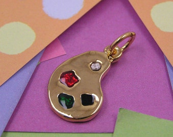 May include: Gold-tone charm shaped like a painter's palette with red, green, black, and clear rhinestones.
