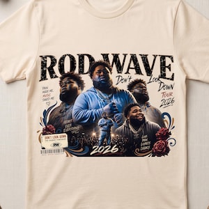 May include: A cream-colored t-shirt featuring a graphic print of Rod Wave with the text "ROD WAVE," "DON'T LOOK DOWN TOUR 2026," "PAIN MADE ME, MUSIC SAVED ME," "HEART OVER EVERYTHING," "LOVE, PAIN, LOYALTY, LEGACY," and "DON'T LOOK DOWN THE JOURNEY CONTINUES."