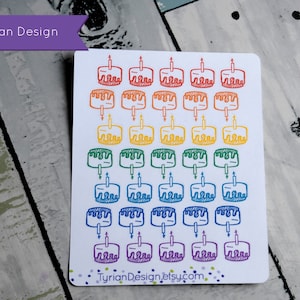 May include: A sheet of stickers featuring a rainbow of birthday cake illustrations. Each cake has a single lit candle. The text "Tyrian Design" is in a purple banner at the top. The website "TyrianDesign.etsy.com" is at the bottom.