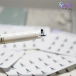 May include: A small sticker featuring a candle design with blue and black accents. The sticker is on a white background, and the image also shows a white marker and other stickers with a similar design. The sticker is from Tiptan Design.