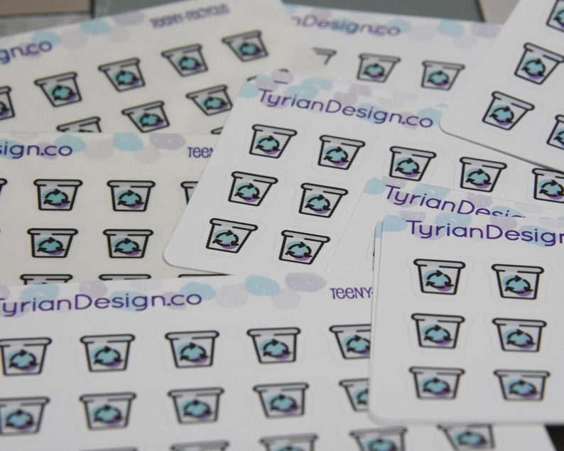 May include: A sheet of white sticker paper with multiple blue and purple recycling bin icons. The paper has the text "TyrianDesign.co" printed on it.