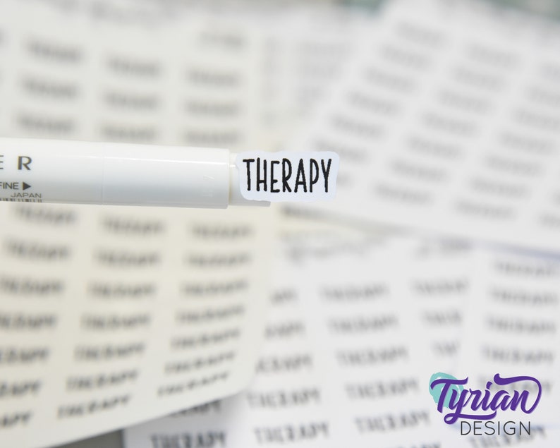 May include: A white marker pen with the word "THERAPY" printed on a white sticker attached to the end of the pen.