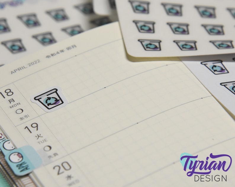 May include: A sheet of stickers with a design of a coffee cup with a recycling symbol. The stickers are white with a light blue and purple design. The stickers are on a white background.
