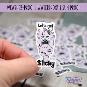 May include: A purple and white sticker with a cartoon unicorn and the text "Let's get Sticky". The sticker is weatherproof, waterproof, and sunproof.