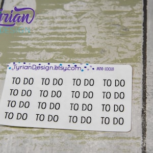 May include: A sheet of white stickers with the text "TO DO" repeated 12 times. The stickers are designed for use in a planner or journal.