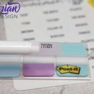 K&ouml;nnte beinhalten: Ein wei&szlig;er Markierstift mit einem durchsichtigen Etikett, auf dem "Tyrian" steht. Der Stift liegt auf einem Satz bunter Haftnotizen.
