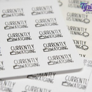 May include: A sheet of white stickers with the text "Currently Watching" and a television icon. The stickers are printed in black ink.