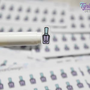 May include: A sheet of clear stickers with a design of a purple nail polish bottle. The stickers are arranged in rows and columns. The stickers are on a white background.