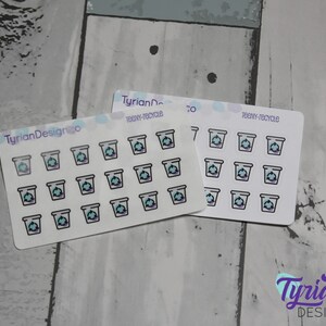 May include: Two sheets of stickers with a light blue background and white outlines. Each sheet has 16 stickers with a recycling symbol inside a small trash can. The text "teeny-recycle" is printed on each sheet.