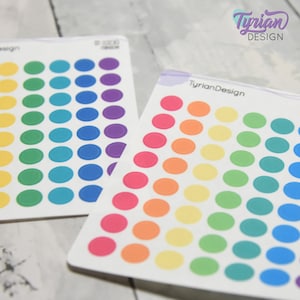 May include: Two sheets of colorful round stickers. The stickers are arranged in a rainbow pattern. The stickers are perfect for planners, journals, and other craft projects.