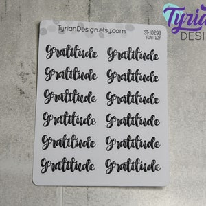 May include: A sheet of 10 clear stickers with the word "Gratitude" written in black cursive script. The stickers are arranged in two rows of five. The sheet is white with a black border.
