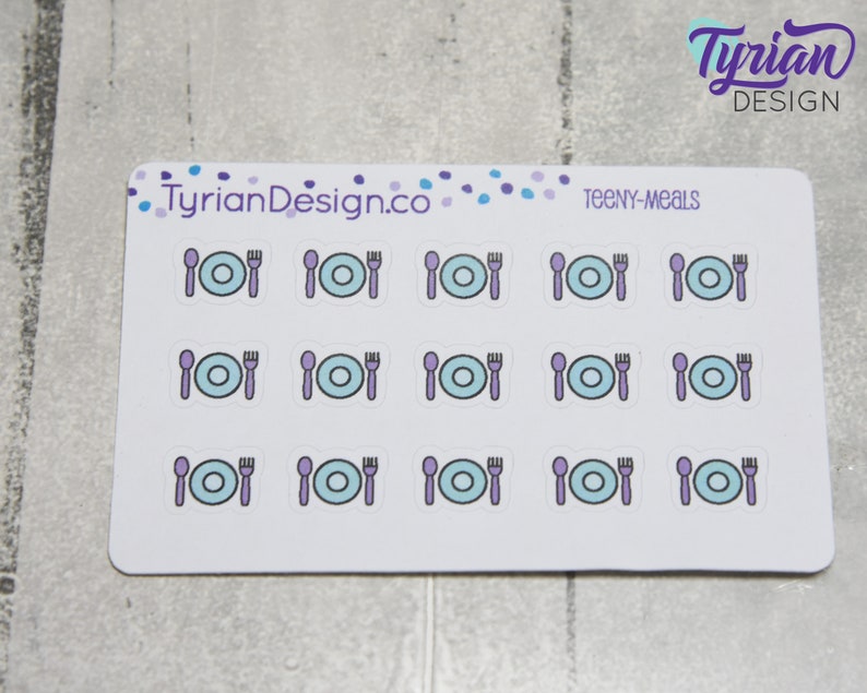 May include: A sheet of 18 stickers featuring a simple design of a plate, fork, and spoon. The stickers are white with light blue plates and purple utensils. The text "TEENY-MEALS" is printed at the top of the sheet.