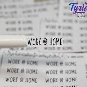 Op de afbeelding: Een close-up van een witte sticker met de tekst "WORK @ HOME" in zwart gedrukt. De sticker zit bovenop een witte marker.