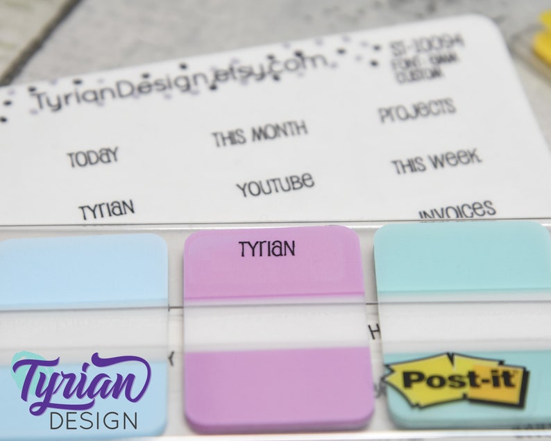 K&ouml;nnte beinhalten: Eine Nahaufnahme eines wei&szlig;en Boards mit dem Text "Tyrian Design etsucom" und "TODAY", "TYRIAN", "THIS MONTH", "YOUTUBE", "PROJECTS", "THIS WEEK" und "INVOICES" darauf geschrieben. Unter dem Board befinden sich drei Haftnotizen, eine hellblau, eine rosa und eine hellblau mit einem gelben "Post-it" darauf. Auf der rosa Haftnotiz steht das Wort "TYRIAN" geschrieben.