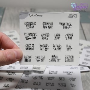 May include: A sheet of clear stickers with black and white illustrations of holidays throughout the year. The stickers include holidays such as Groundhog Day, St. Patrick's Day, Cinco de Mayo, Mother's Day, Father's Day, Flag Day, Patriot Day, Sweetest Day, All Saints Day, Election Day, Chinese New Year, Valentine's Day, April Fools, Earth Day, Arbor Day.