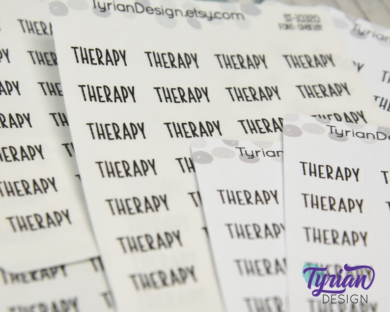May include: A sheet of white sticker paper with the word "Therapy" repeated multiple times in black text. The stickers are designed for use in a planner or journal.