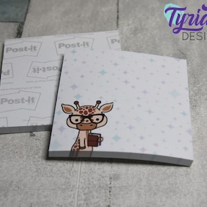 Op de afbeelding: Een stapel Post-it-briefjes met een schattige cartoon-giraf die een bril draagt en een boek vasthoudt. De achtergrond is lichtblauw met witte sterren.