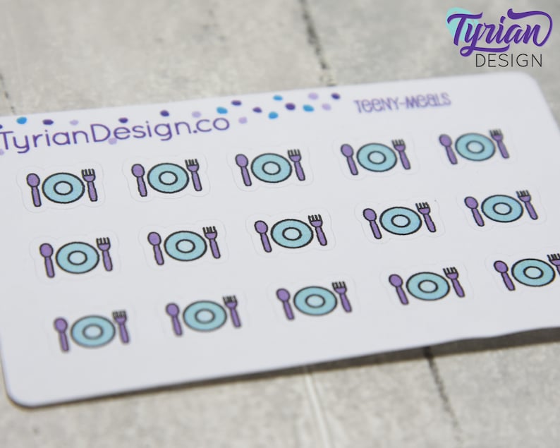 May include: A sheet of stickers with a white background and purple and blue illustrations of plates, forks, and spoons. The text "TEENY-MEALS" is printed at the top of the sheet.
